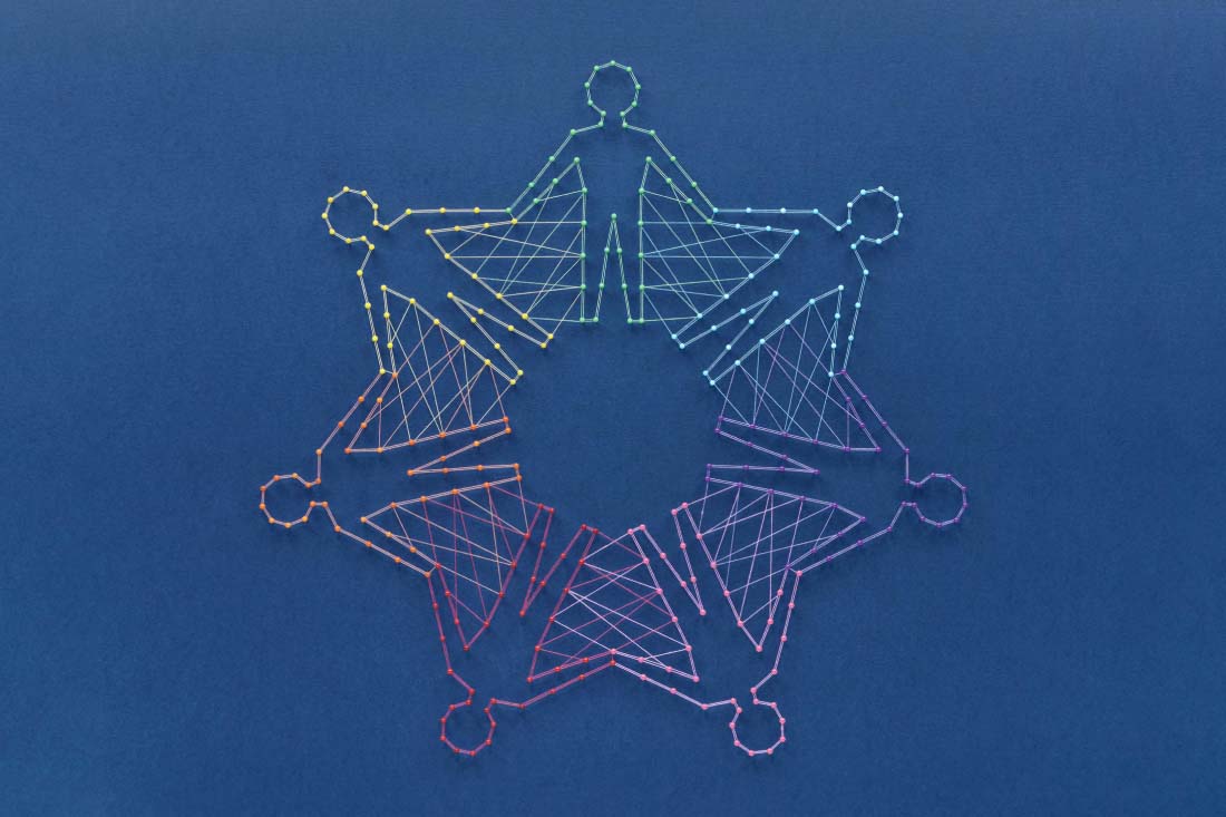 Different colored strings that look like people holding hands in a circle to symbolize a diverse culture committee.