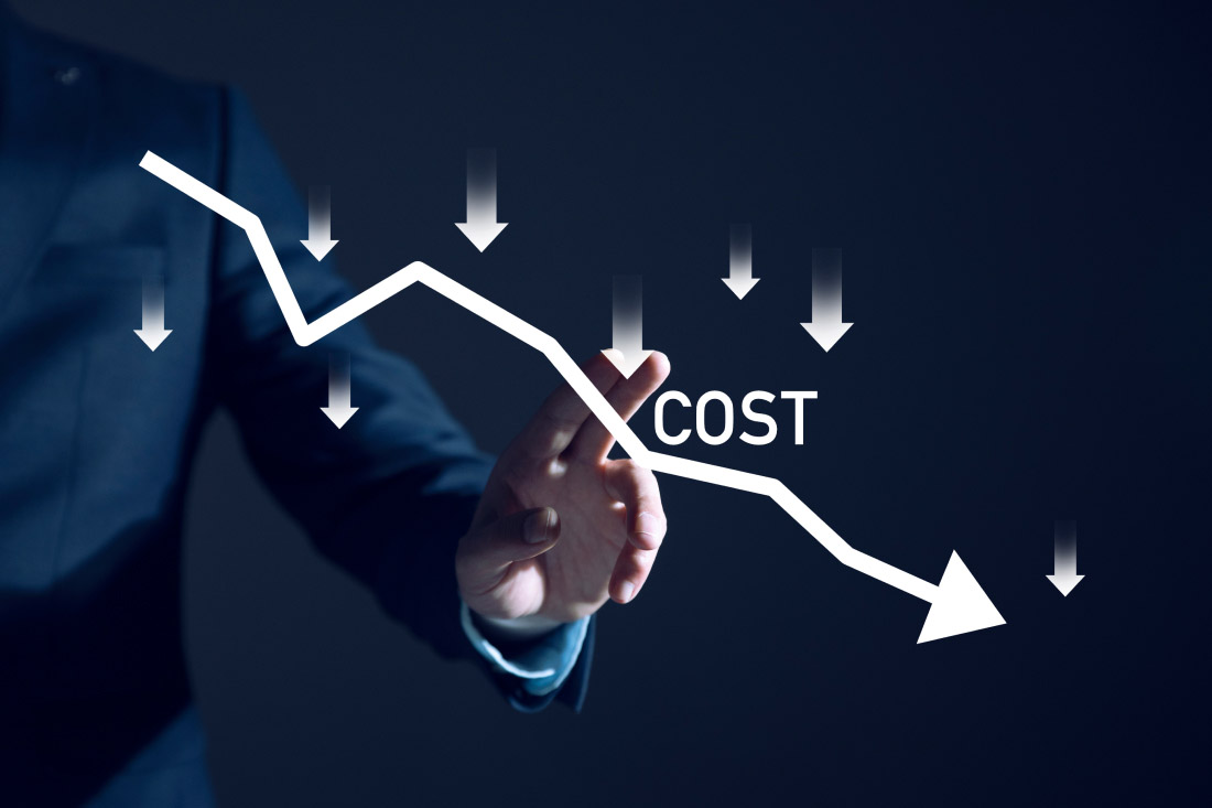 Businessman pointing at downward cost reduction graph with arrows.