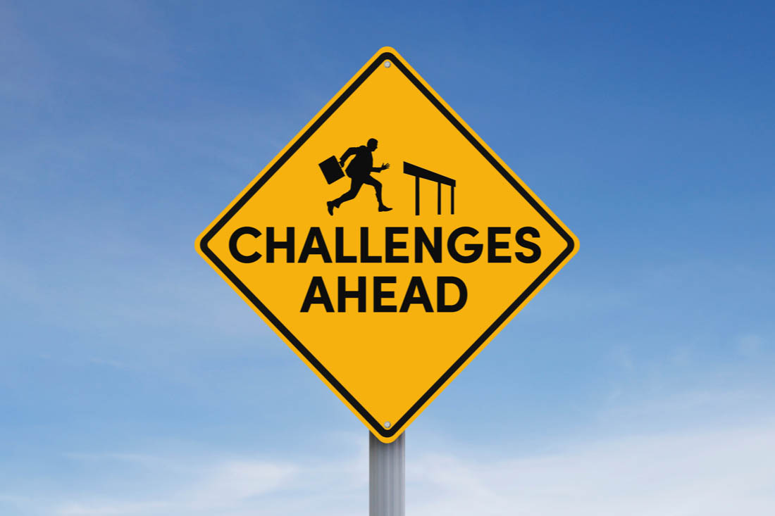 A street sign with ‘challenges ahead’ to symbolize the challenges of hybrid workforce management.