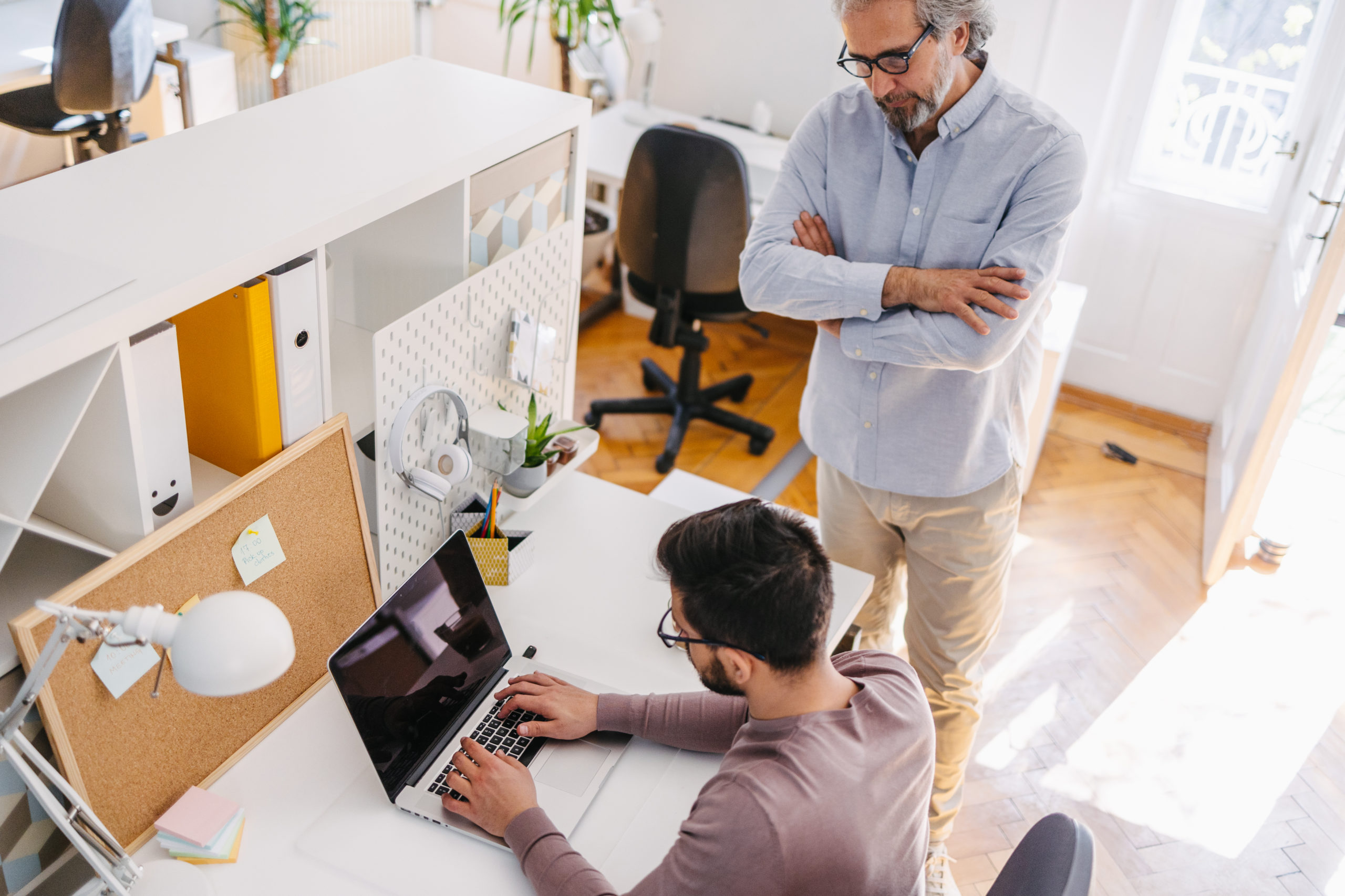Senior manager angry with younger employee, listening excuses in the office. Arms crossed