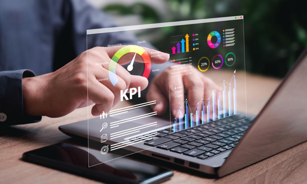 Person using a laptop with digital KPI and analytics dashboard on screen.